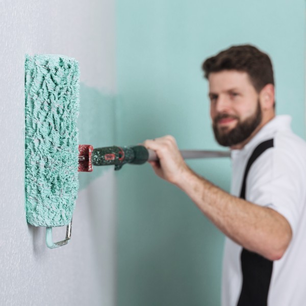 ein Mann malt eine Wand