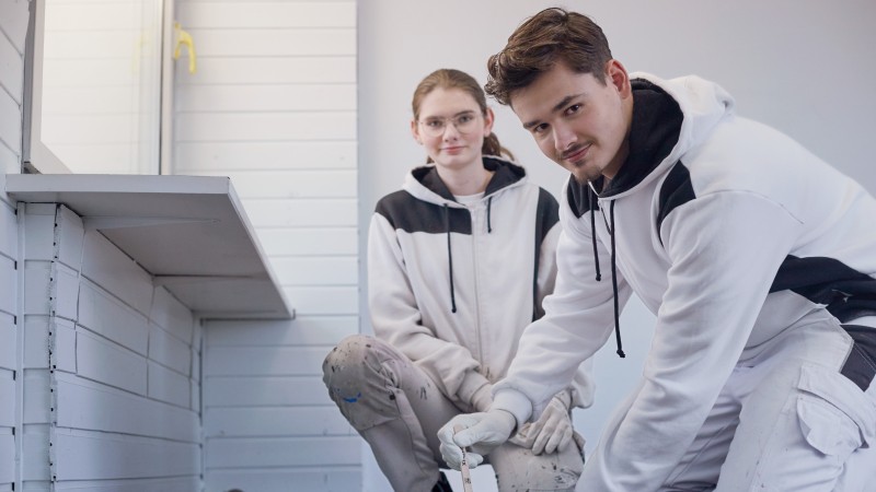 Mehrere junge Menschen stehen vor einem bunten Show-Truck