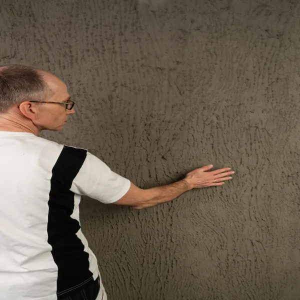 ein Mann und eine braune Wand
