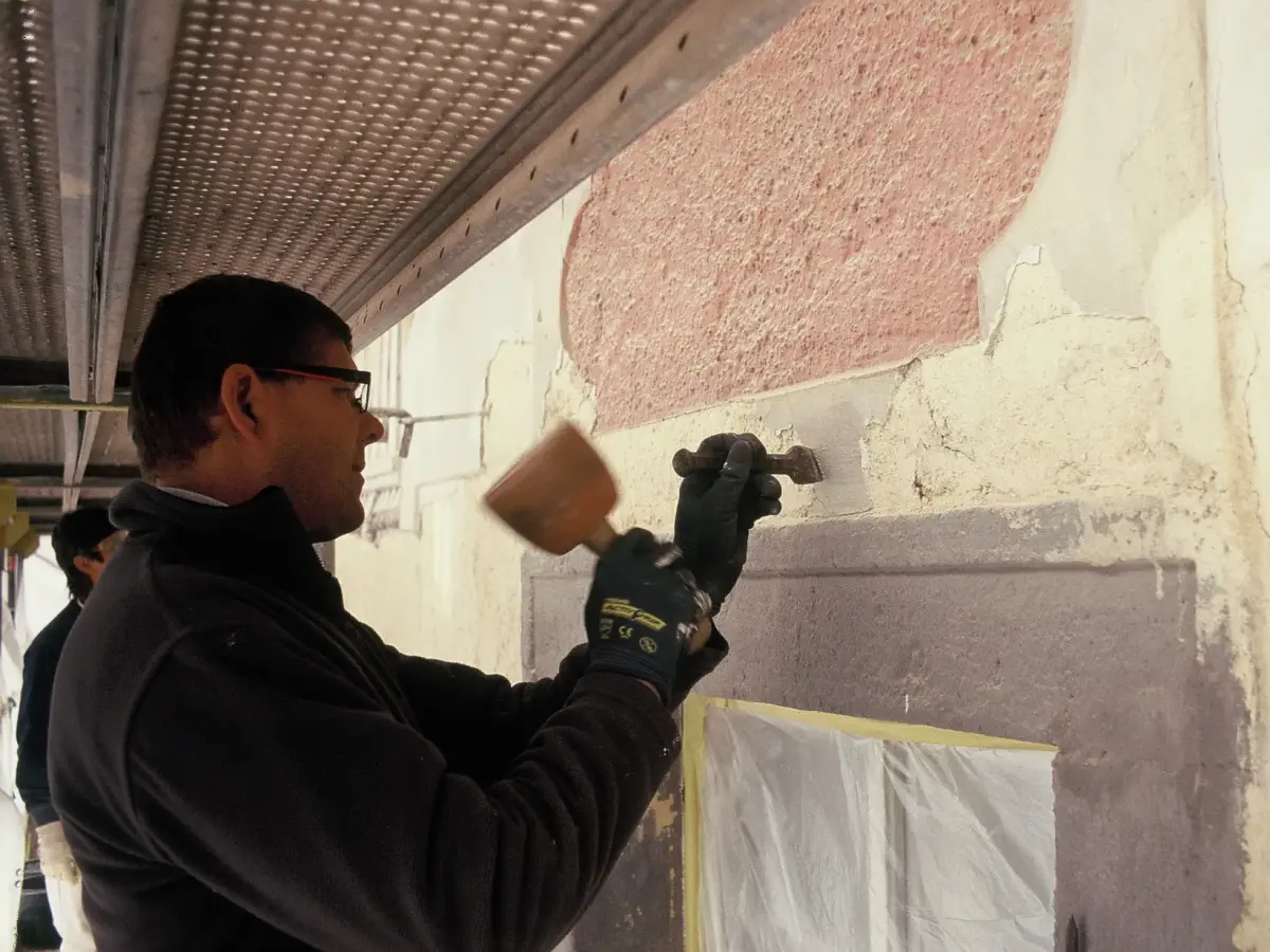 zwei Männer beim Putz abklopfen dere Fassade