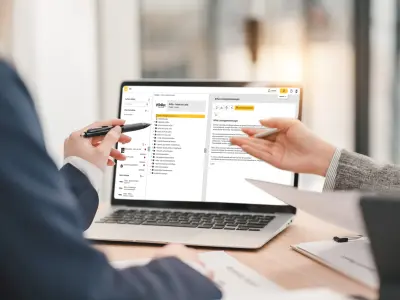 zwei Männer gucken auf einen Screen der Brillux Website