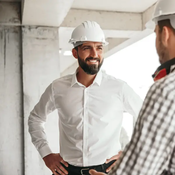 zwei Männer auf einer Baustelle stehen gegenüber
