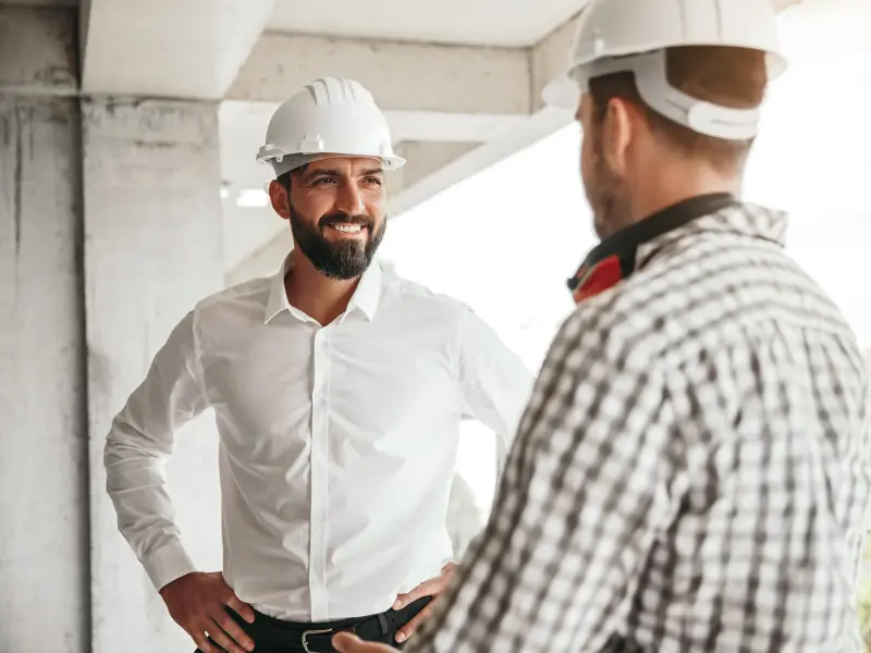 zwei Männer auf einer Baustelle stehen gegenüber