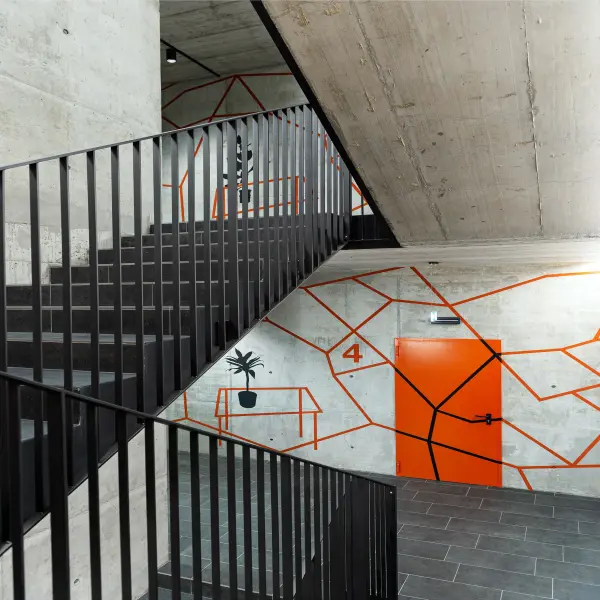 Beton Treppenhaus mit roten Streifen und roter Tür 