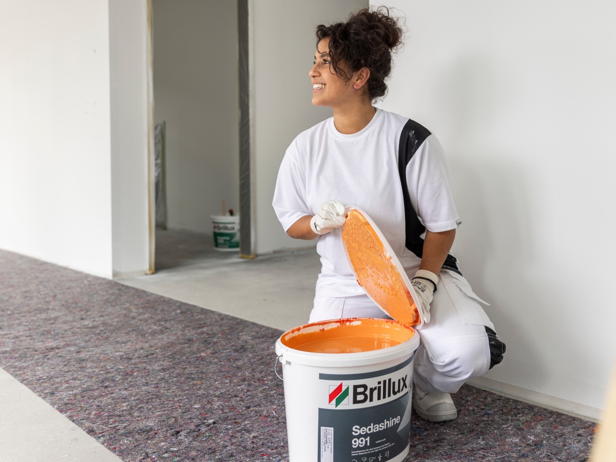 Eine Frau öffnet einen Eimer mit Sedashine.