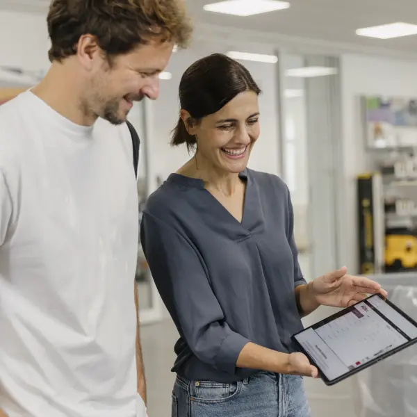 Frau zeigt Mann Tablet 
