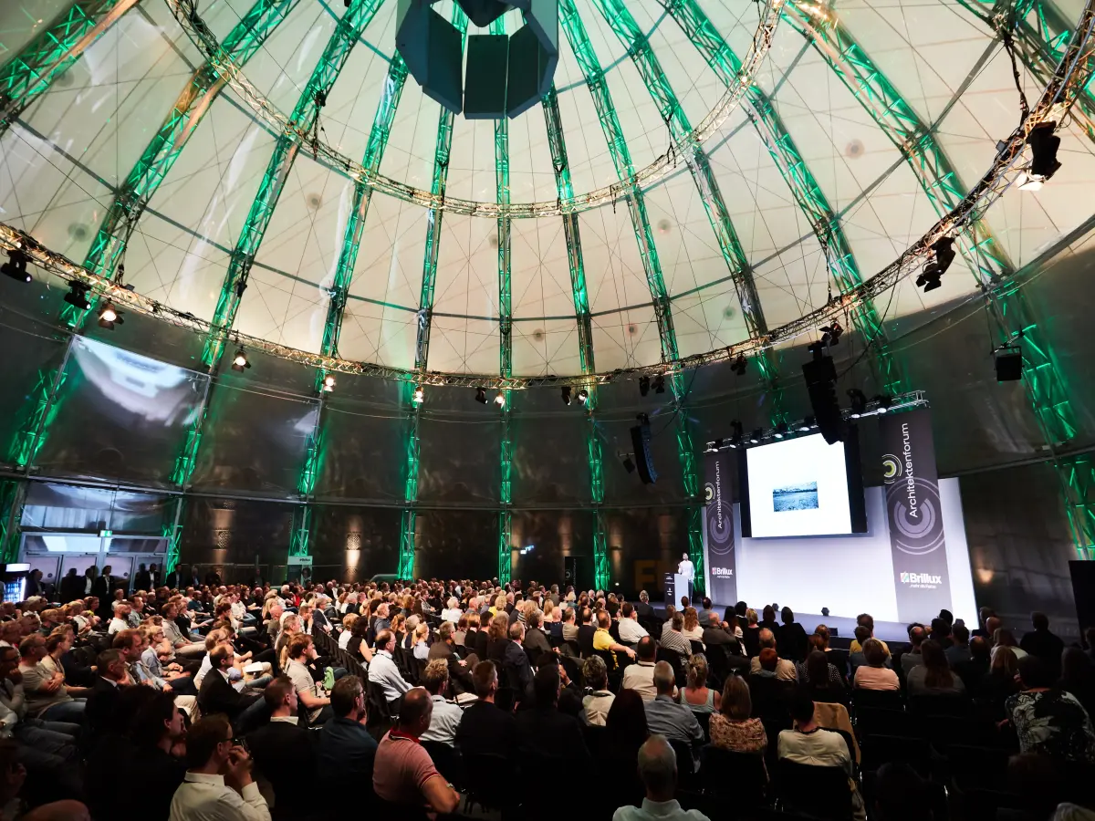 Berlin: Es ist ein großer Saal zu sehen, in dem Personen in Stuhlreihen sitzen.