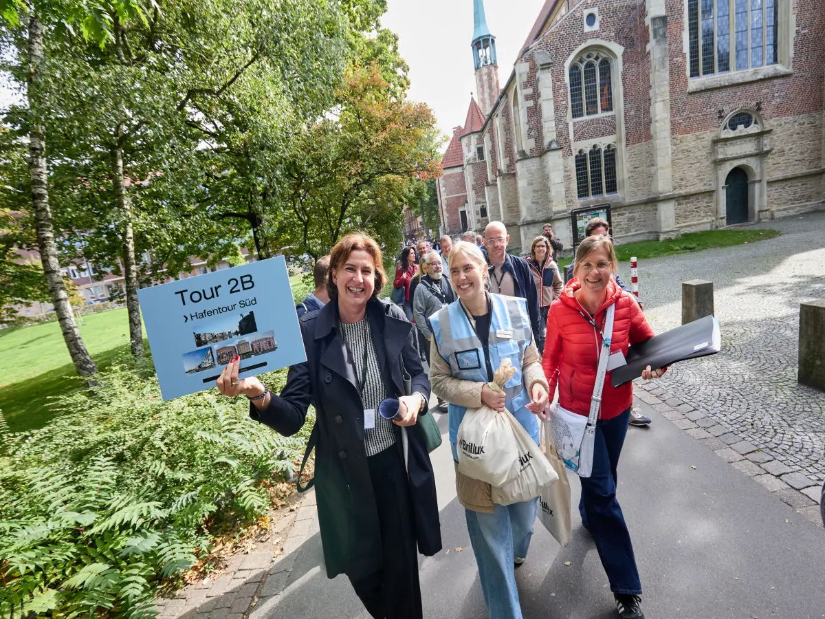 Münster: Es sind drei Frauen zu sehen, die in die Kamera lachen.