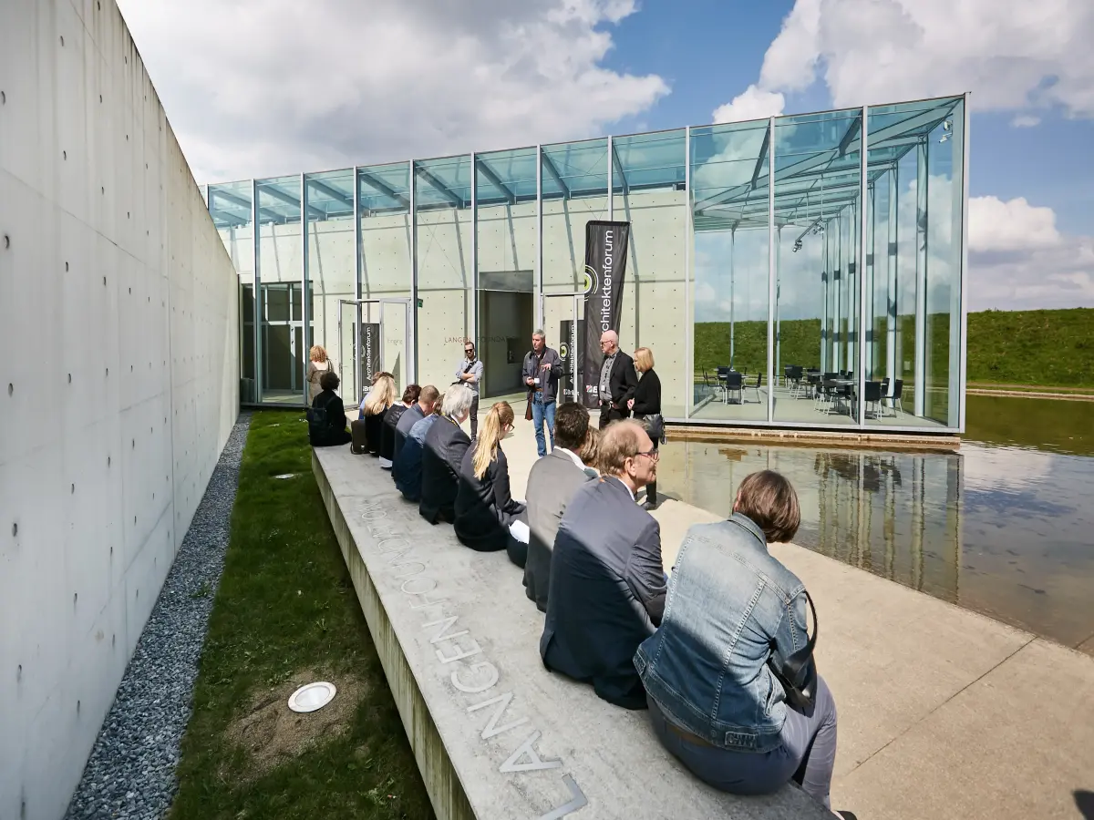 Düsseldorf: Menschen sitzen auf einer Betonbank.