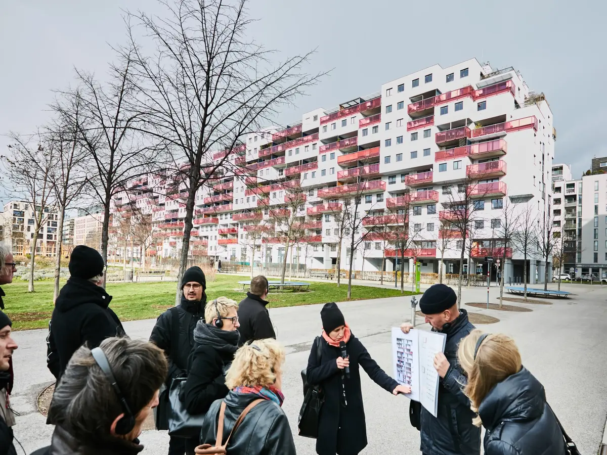 Wien: Es sind Menschen zu sehen, die einer Person zuhören, die etwas vorträgt.