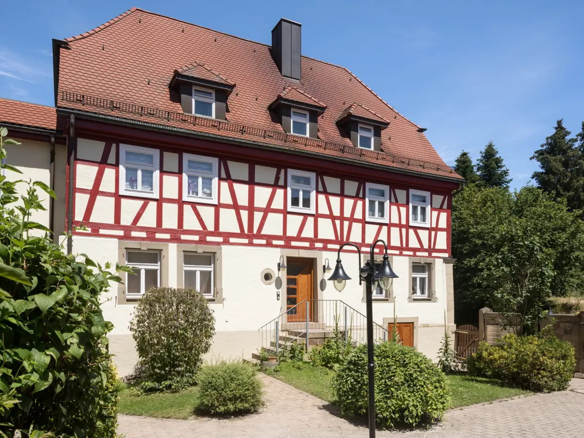 Weißes Haus mit Holz-Verzierung in Rot