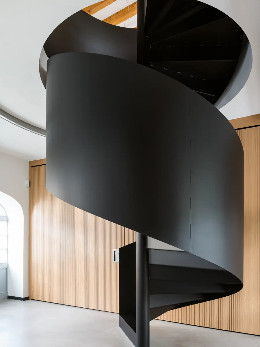 Spindeltreppe verschwindet im oberen Teil der Decke in einem runden Loch 