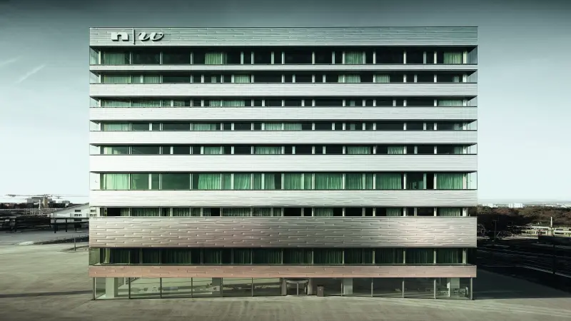 Modernes, mehrstöckiges Gebäude mit Metallfassade, großen Fenstern und "nw"-Logo oben links.
