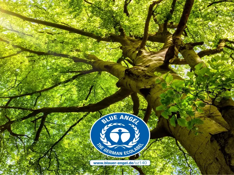Un albero verde alla luce del sole con il logo Blue Angel