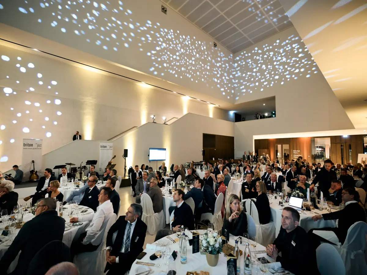 Ein Foyer mit mehreren an Tischen sitzenden Personen