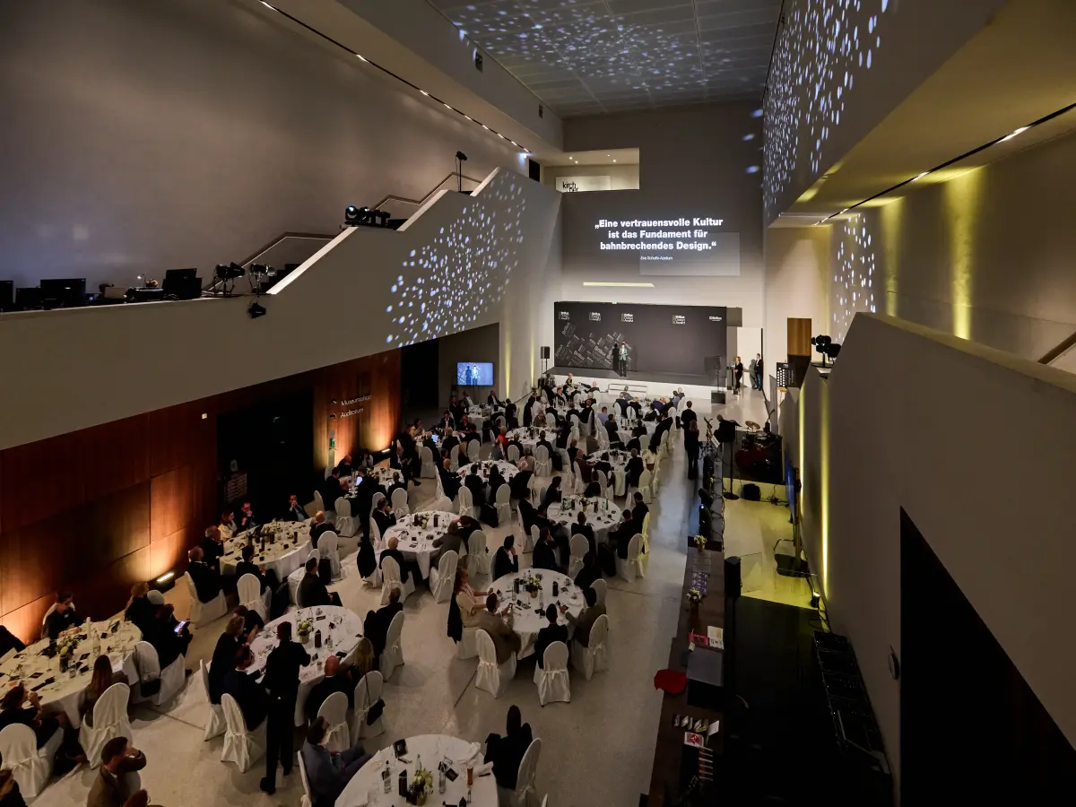 Blick in ein Foyer mit mehrere Personen an Tischen