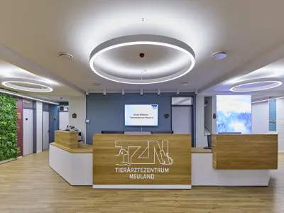 Moderner Empfangsbereich einer Tierarztpraxis mit Holz­tresen und runden Deckenleuchten.