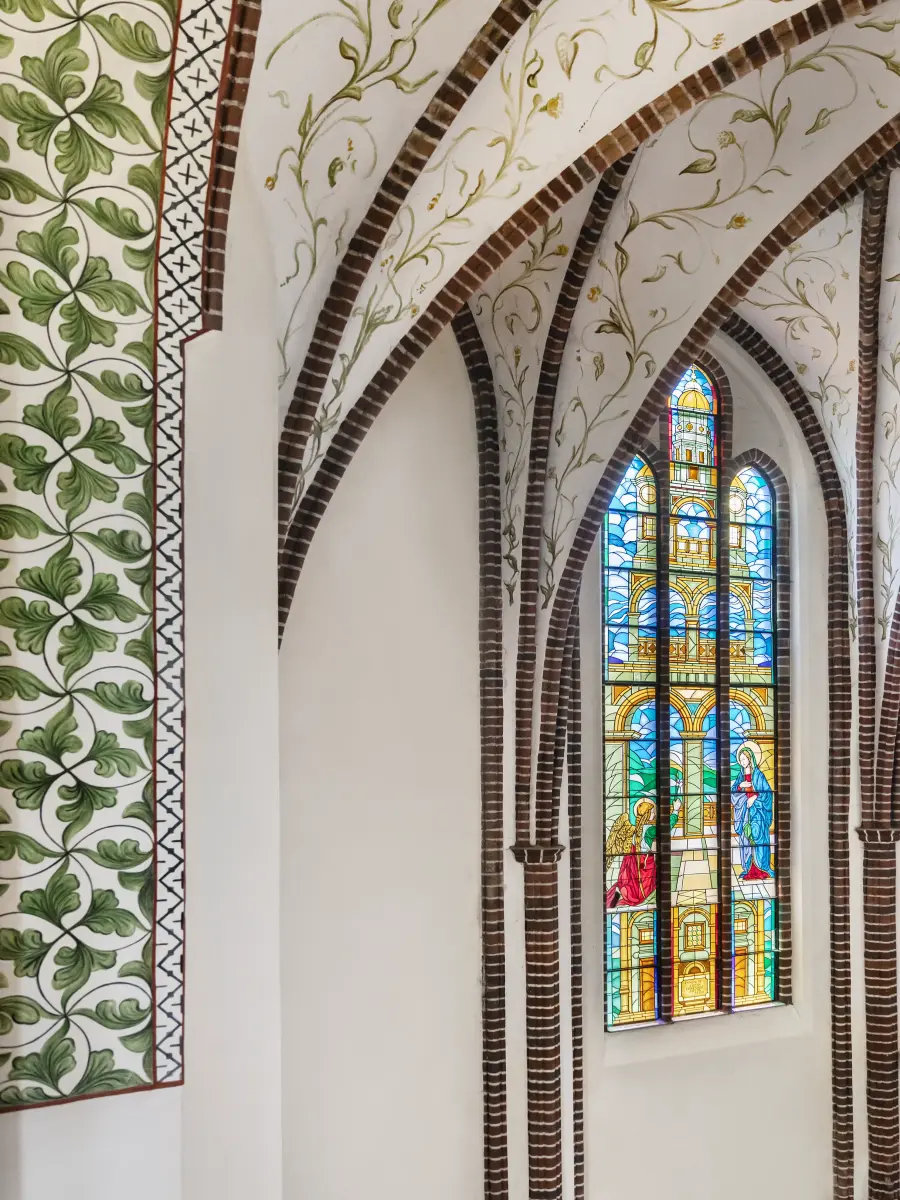 Bunte Fenster und grüne Ornamente an den Wenden