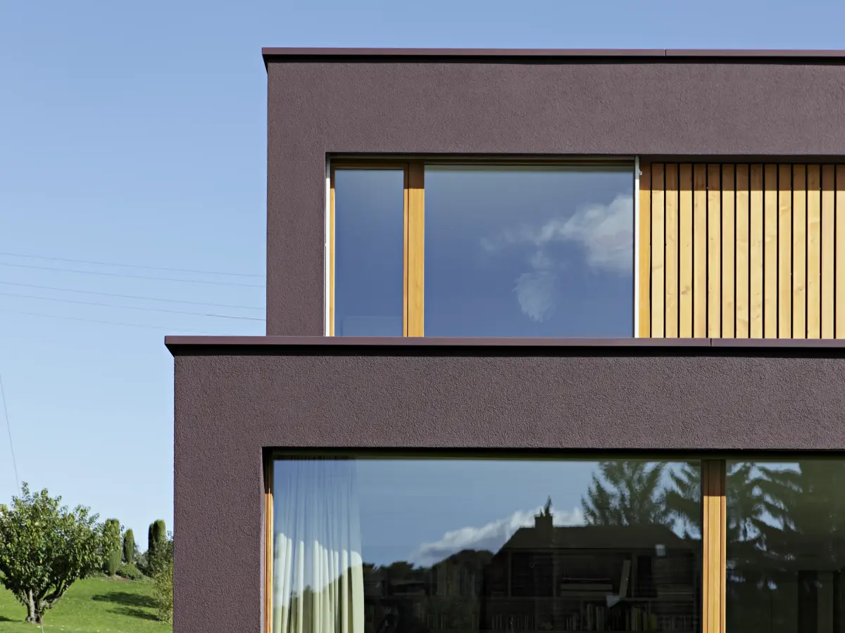 Ein bordeaux farbendes Haus mit Fenstern