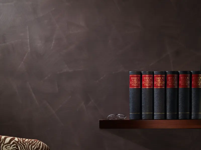 Ein Sessel und ein Bücherregal vor einer Wand