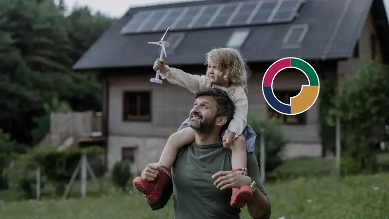 Kind ist auf den Schultern ihres Vaters und hält eine Spielzeug-Windmühle in die Luft