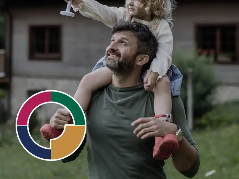 Ein Vater mit seiner Tochter auf den Schultern, die eine Windmühle hält