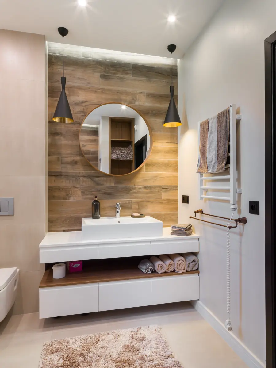 Helles Badezimmer mit moderner weißer Einrichtung. Dazu hölzerne Details.