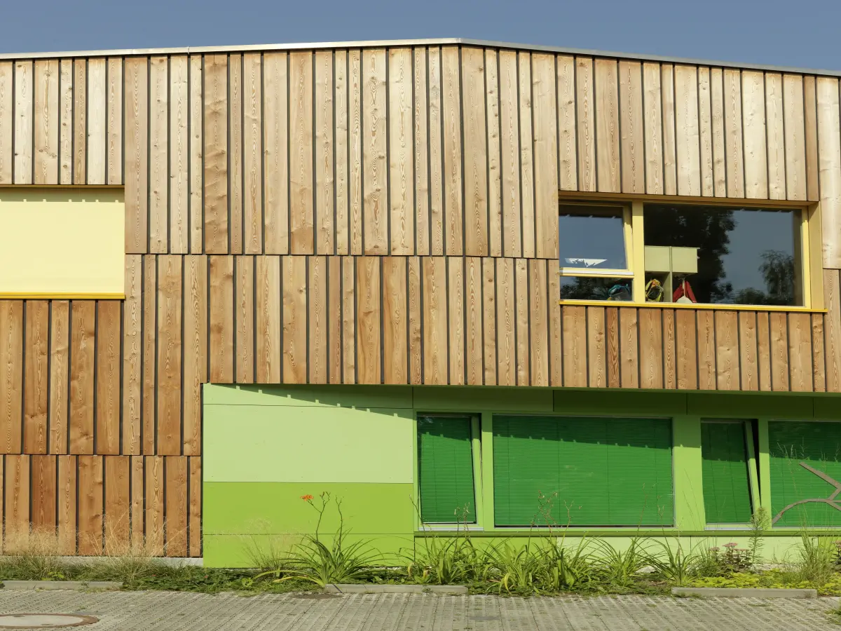 Außenfassade mit Holz und grünen Elementen