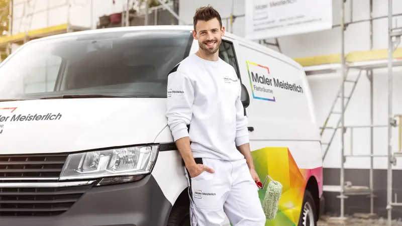 Ein Maler steht vor einem Lieferwagen