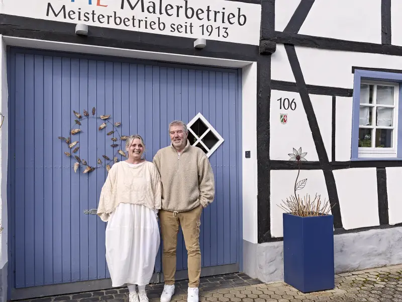 Katharina und Roland vor einem blauen Tor