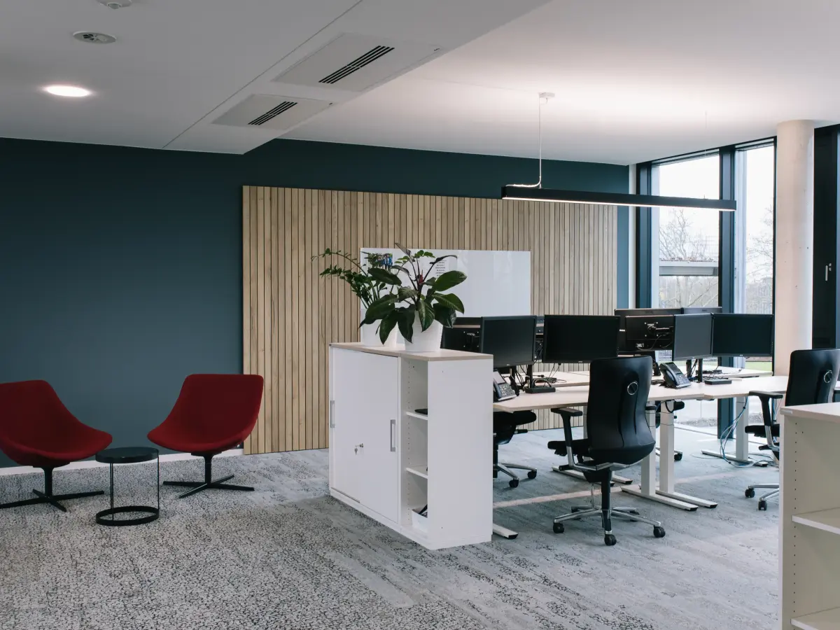 Blick in Büro Bereich: 2 Sessel mit kleinem Tisch neben Schreibtischzeile