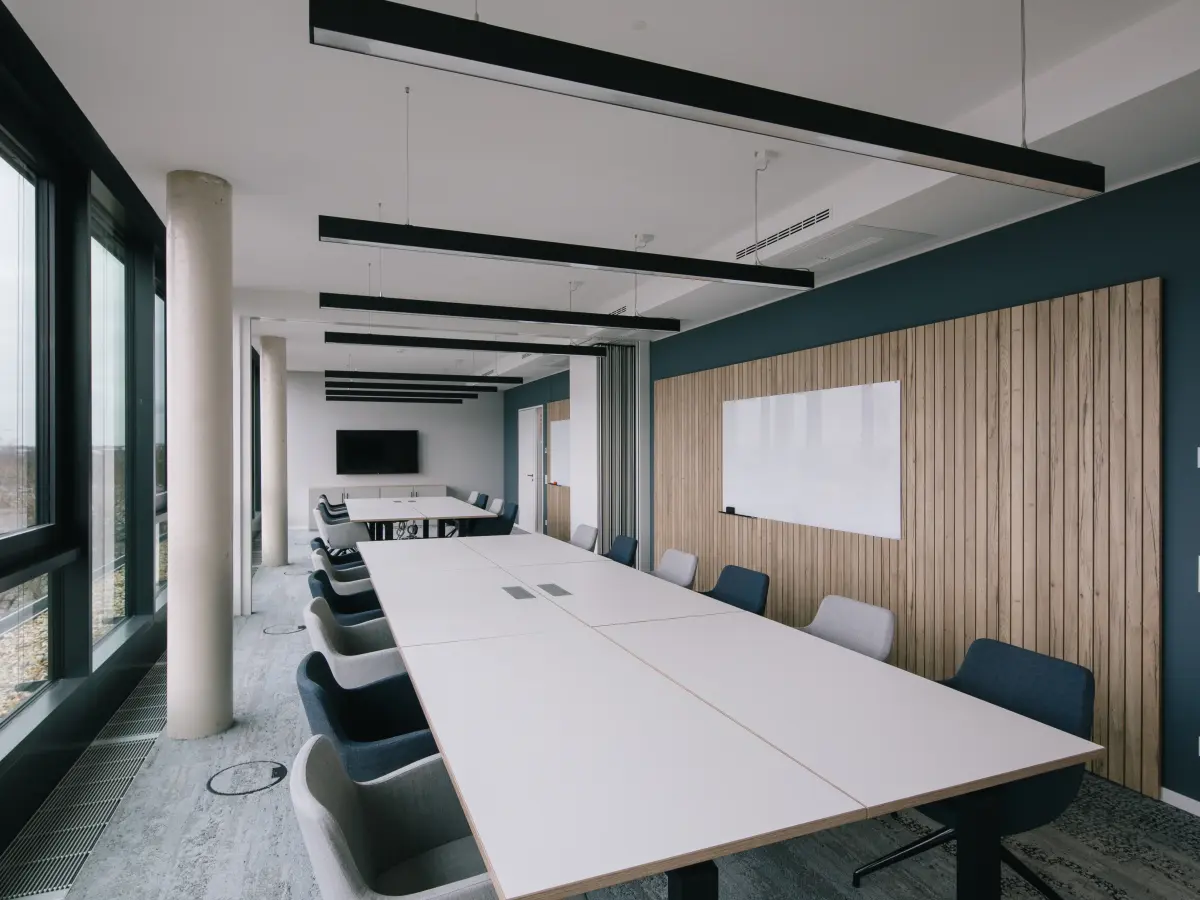 moderner Konferenzraum mit langer Tafel und vielen Stühlen