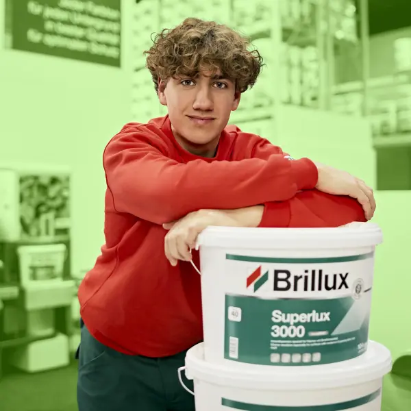 Ein junger Mann mit blonden Locken schaut in die Kamera