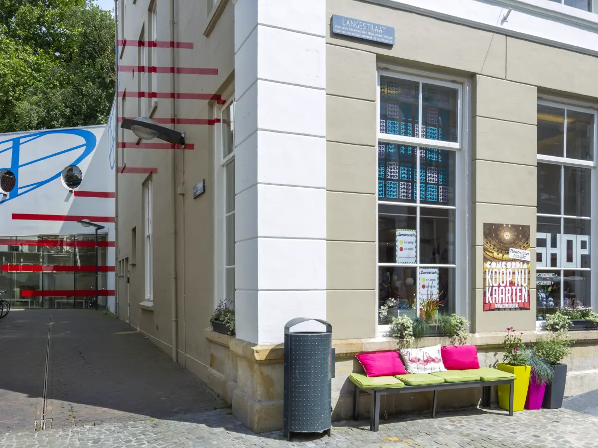 Hausecke mit Bank und Kissen vor einem Fenster