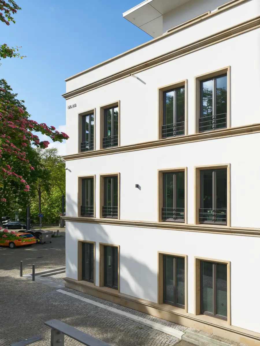 ein Gebäude mit weißen Wänden und gelben Fensterrahmen