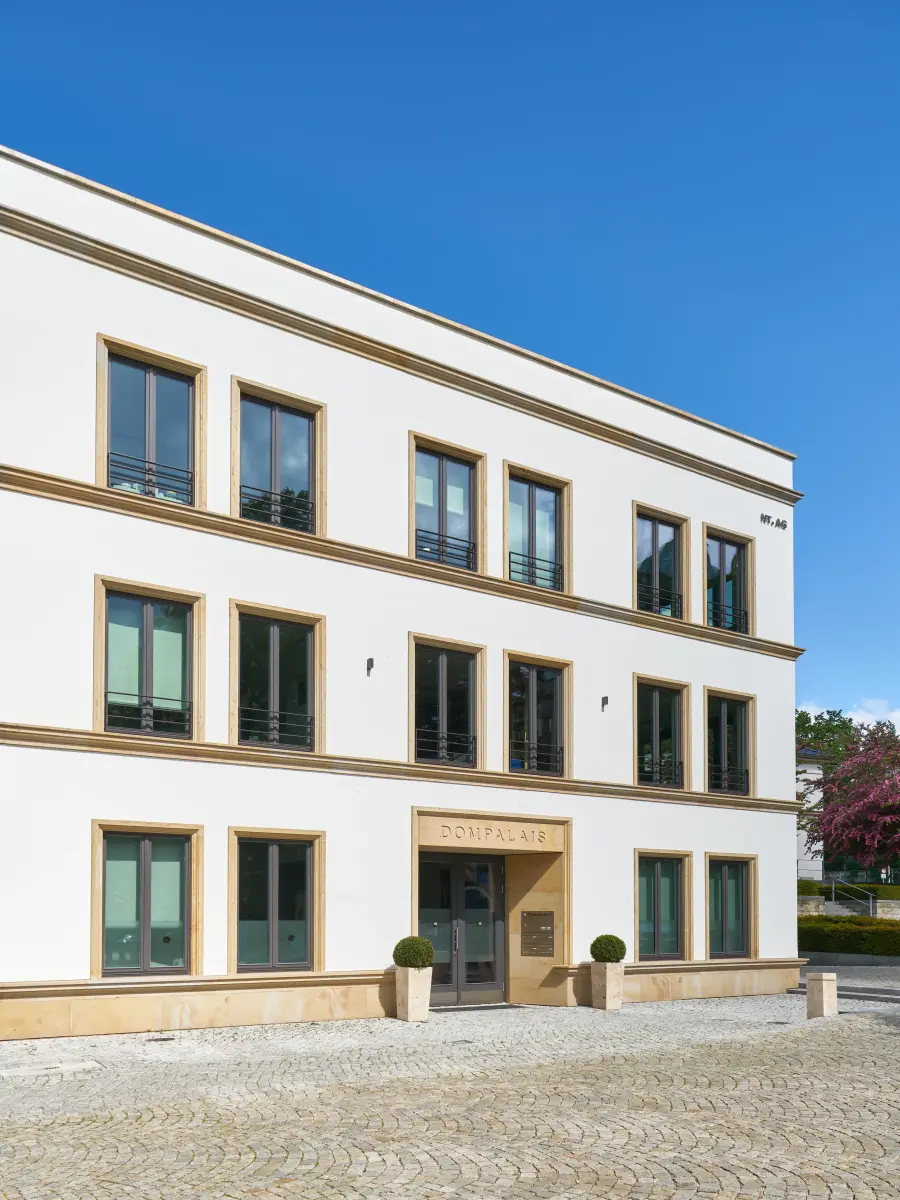 ein Gebäude mit weißen Wänden und gelben Fensterrahmen