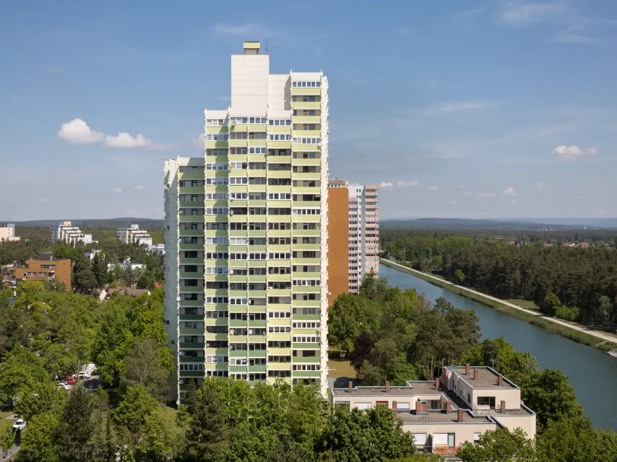 ein Hochhaus-Komplex in den Farben grün, orange, gelb und weiß