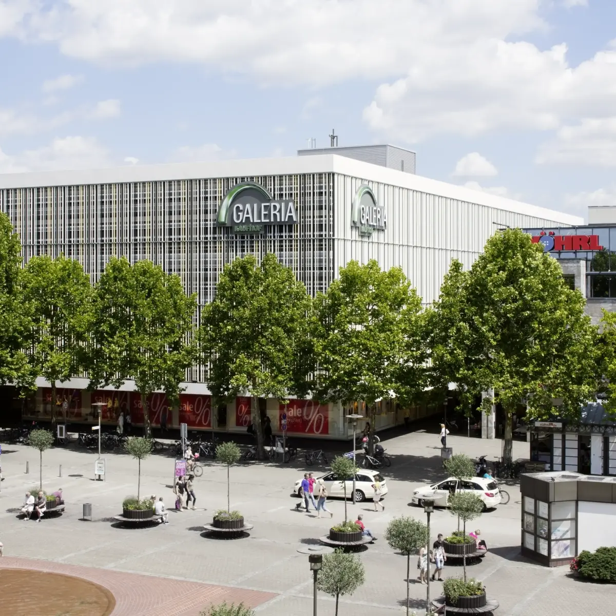 Platz mit Allee von Bäumen und Gebäude Galeria
