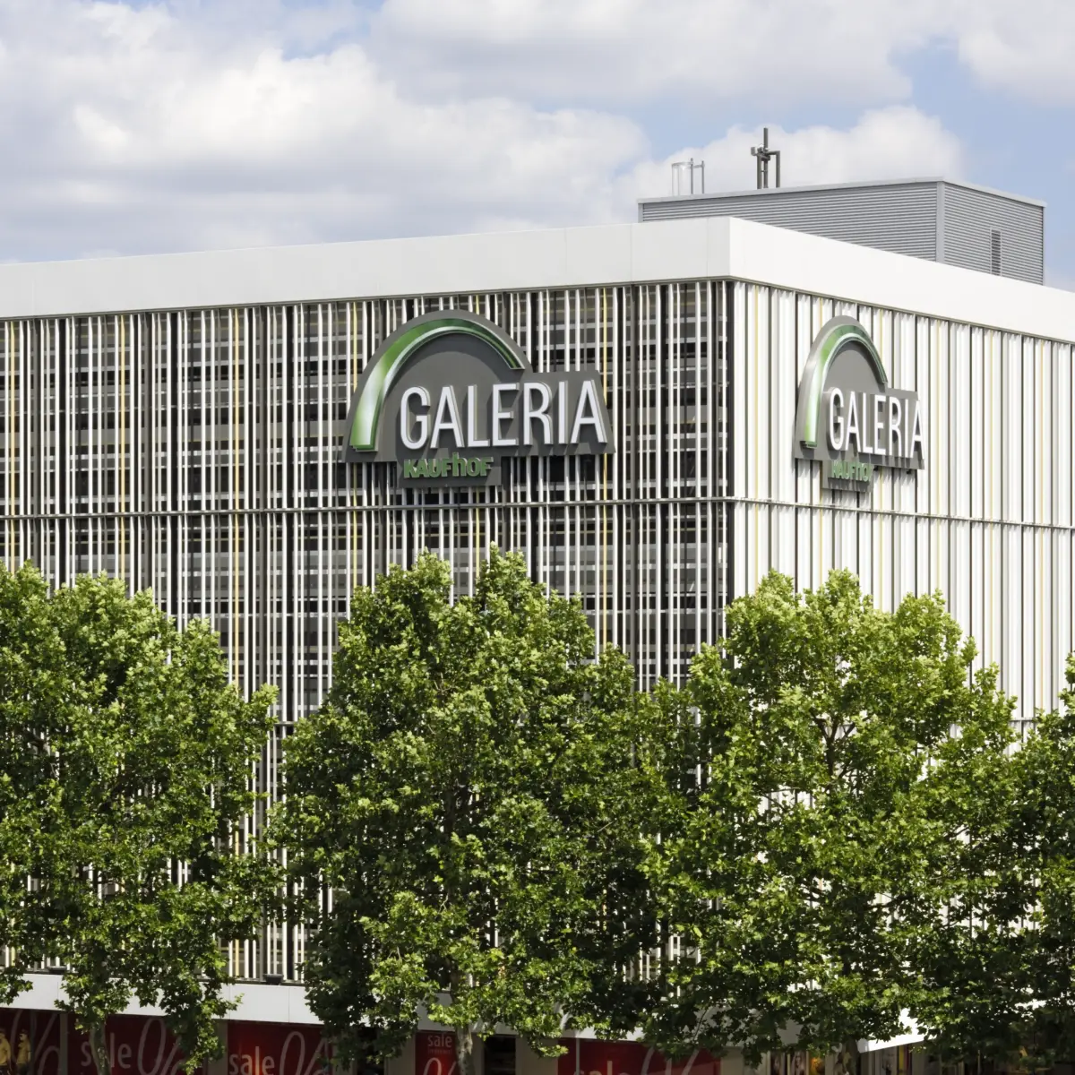 dreidimensionale Gewebestruktur Galeria Gebäude Ecke mit Bäumen im Vordergrund 