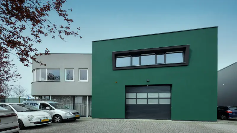 Grüne Fassade mit Garagentor