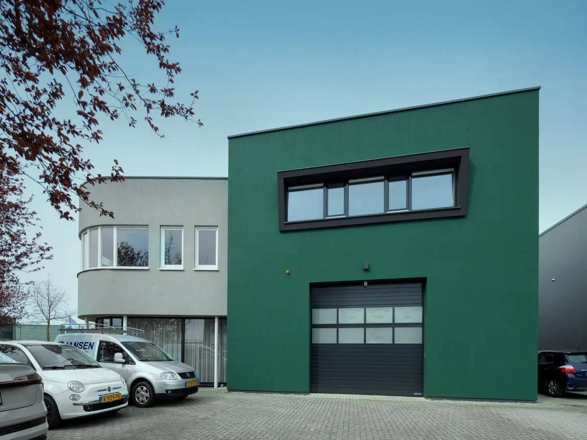 Grüne Fassade mit Garagentor