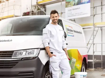 Maler lehnt vor dem Firmenauto