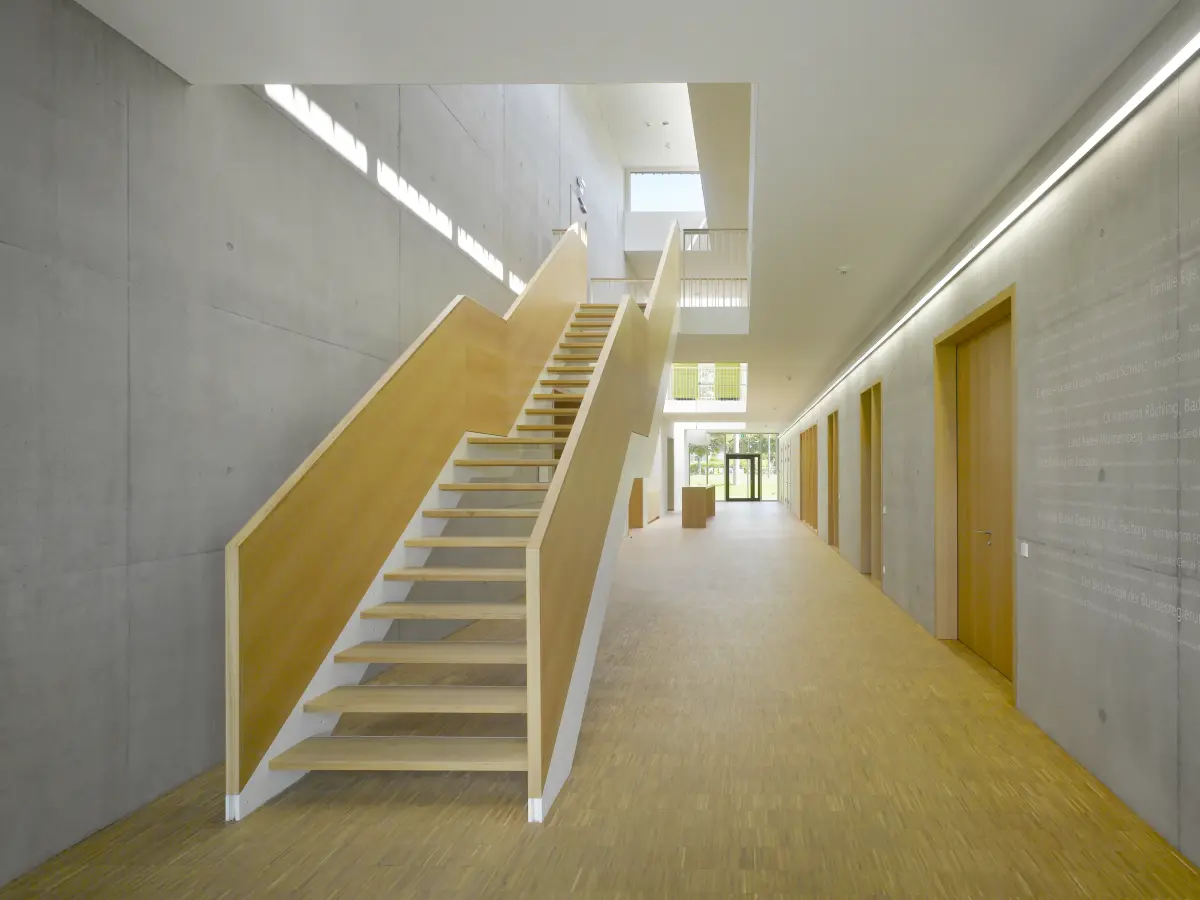 moderner Flur mit Beton Wänden und Holz Treppe und Türen