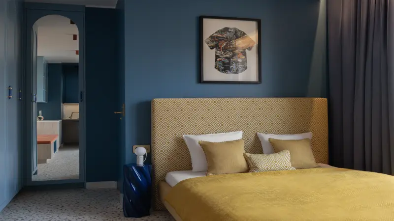 Blau gestrichen Wände im Schlafzimmer mit gelb bezogenen Bett