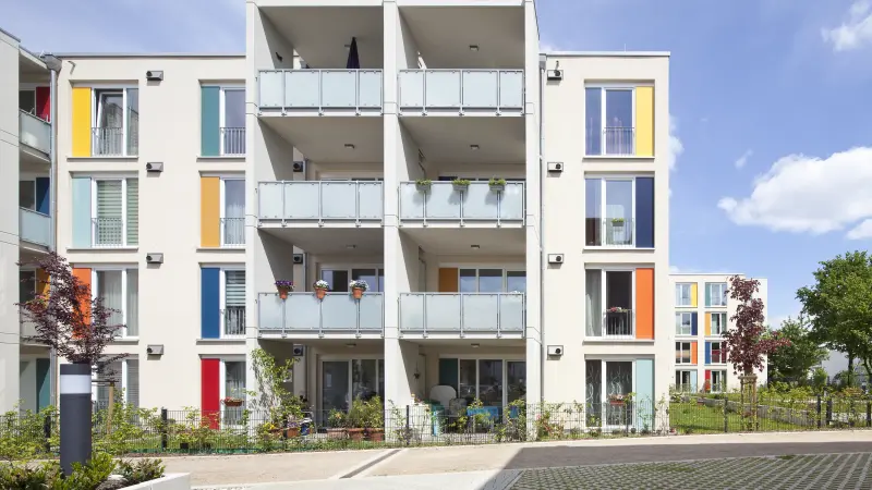 Gebäude mit weißen Fassaden und bunten Fensterrahmen