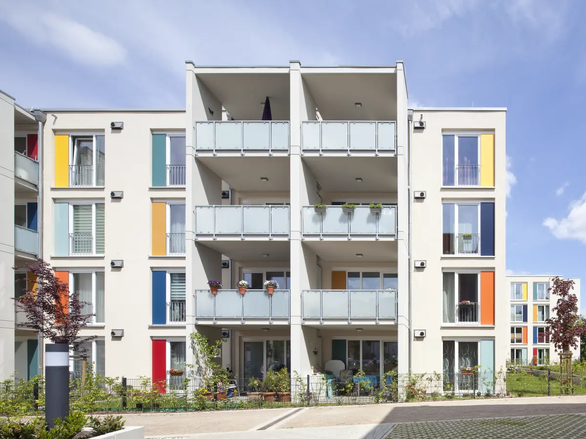 Gebäude mit weißen Fassaden und bunten Fensterrahmen