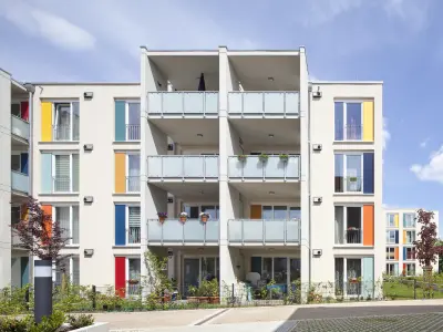 Gebäude mit weißen Fassaden und bunten Fensterrahmen