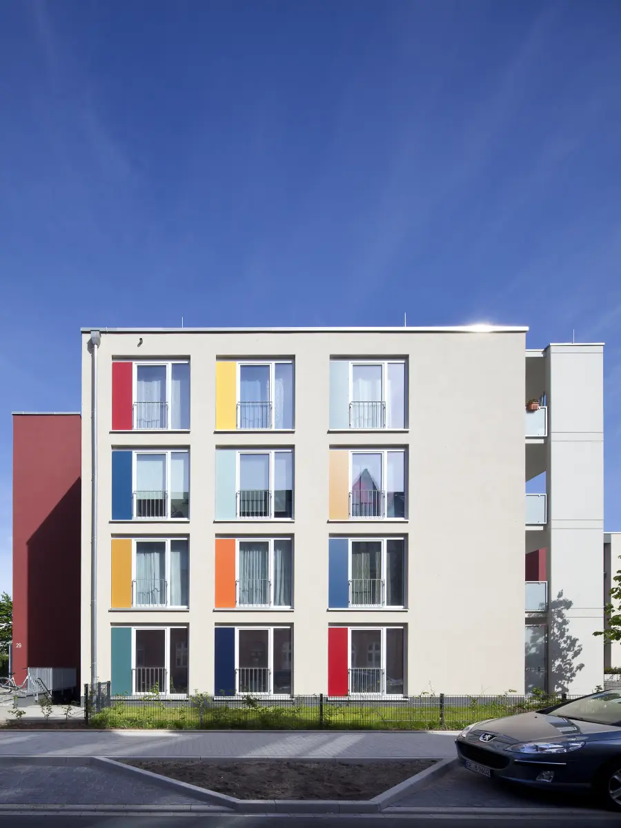 Gebäude mit weißen Fassaden und bunten Fensterrahmen