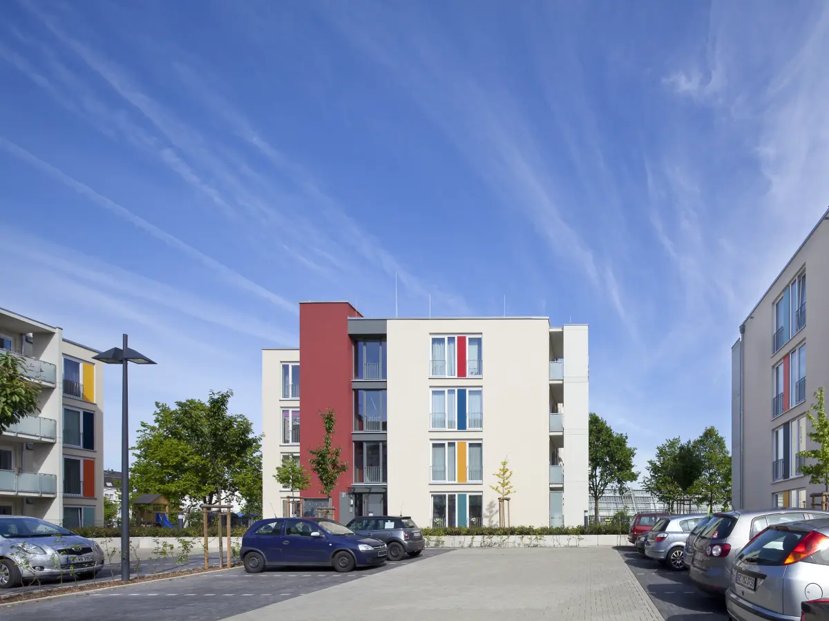Gebäude mit weißen Fassaden und bunten Fensterrahmen