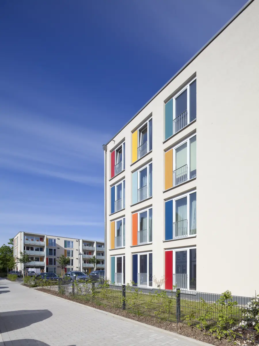 Gebäude mit weißen Fassaden und bunten Fensterrahmen
